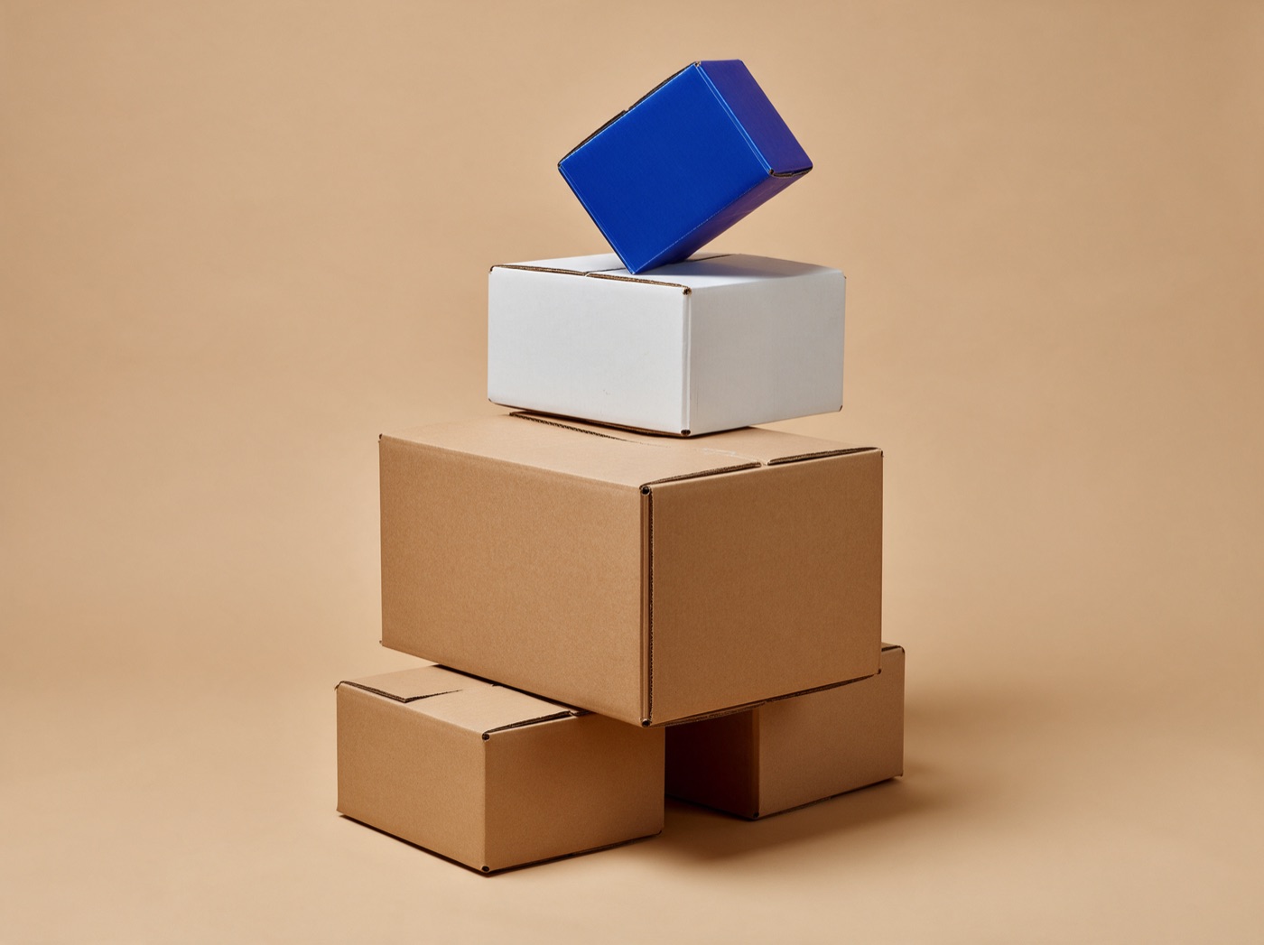 Double-wall shipping cartons stacked, in kraft, white and cobalt blue